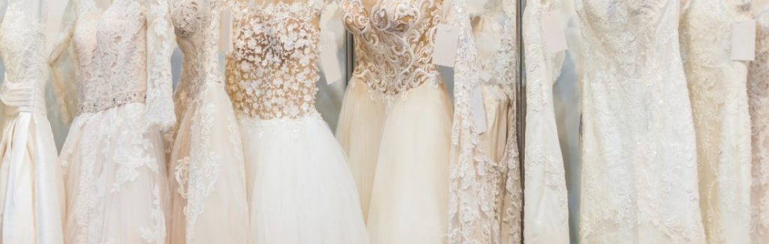 Many beautiful wedding dresses hang in the store