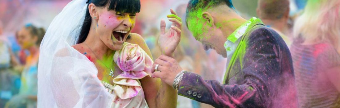 Young cheerful couple at Holi paint party